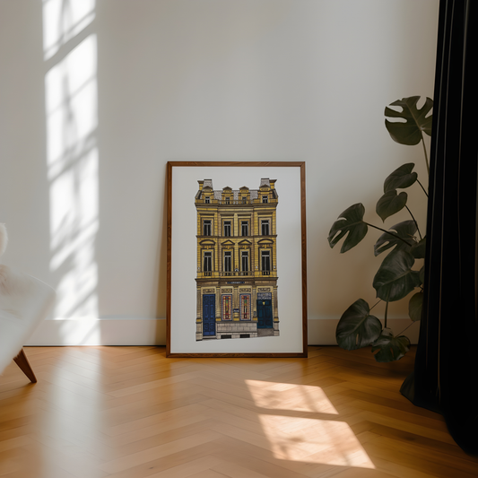 Framed artwork of the crown posada pub on a wall with natural light and a plant in the corner.