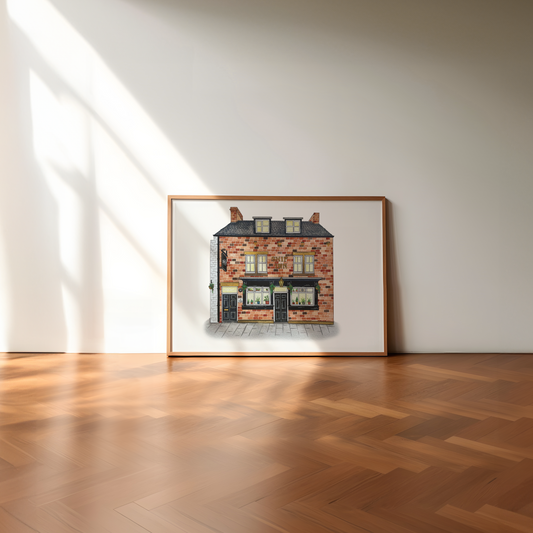 Framed artwork of a brick building on a white wall with wooden flooring.