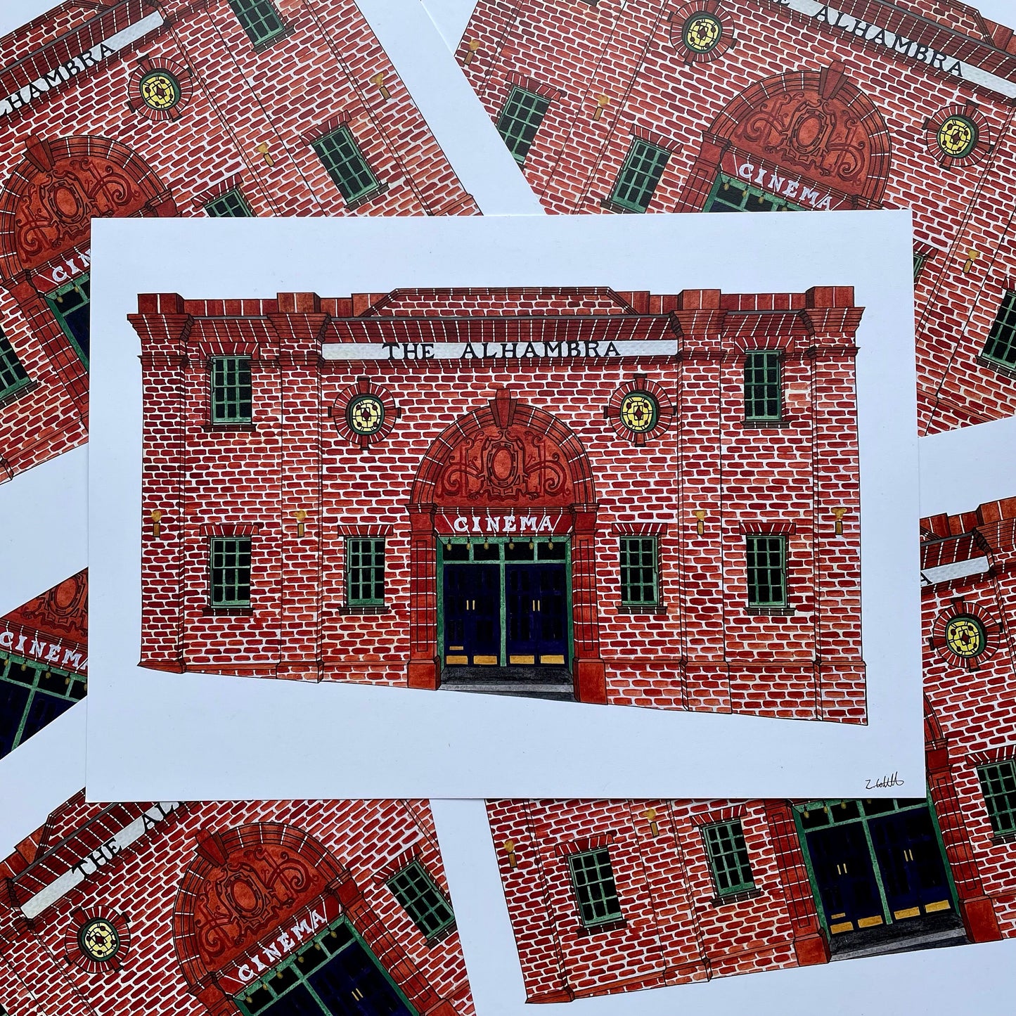 Illustration of a red brick building labeled 'The Alhambra Cinema' on a white background.