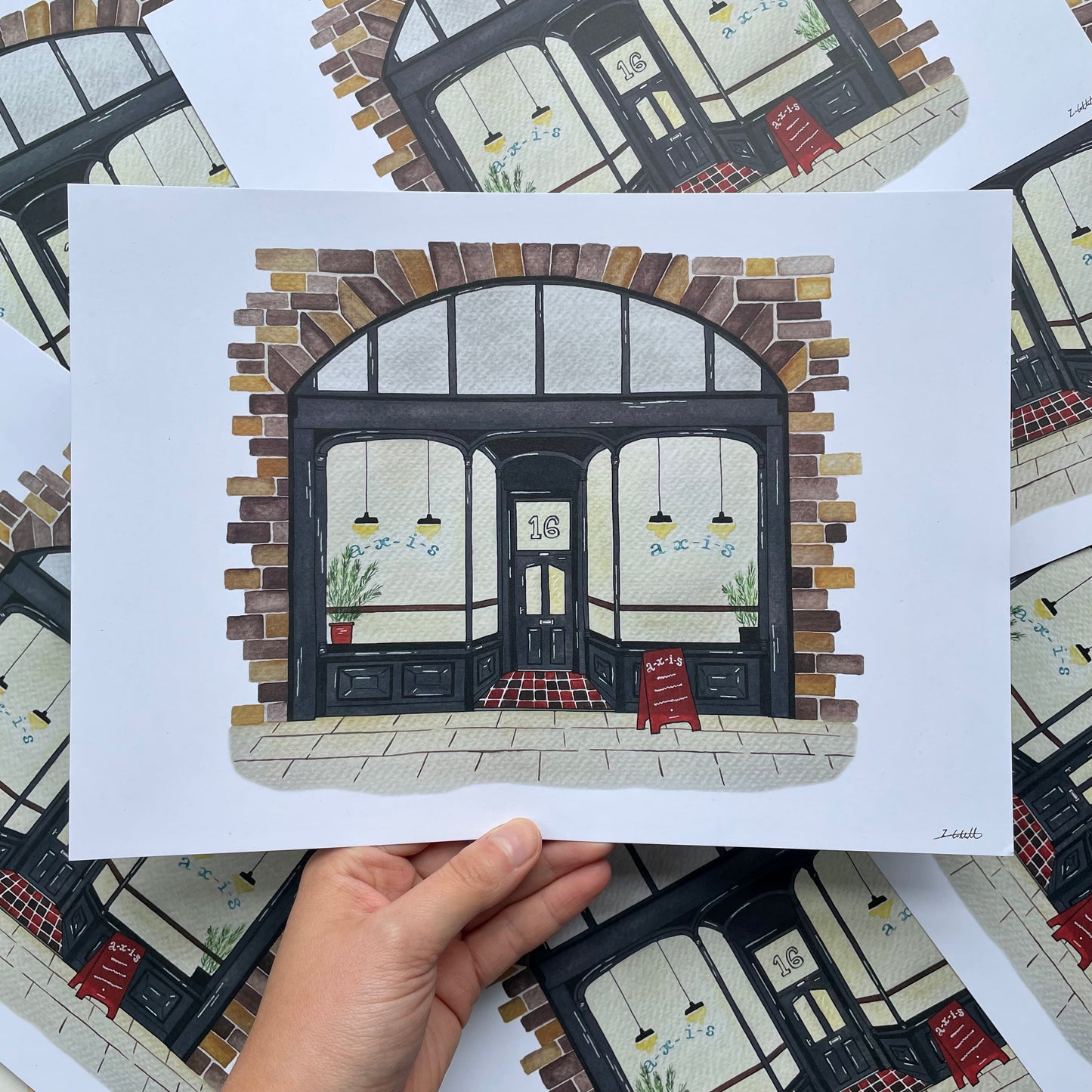 Art print of Axis Bar, Gateshead held by a hand on a patterned surface