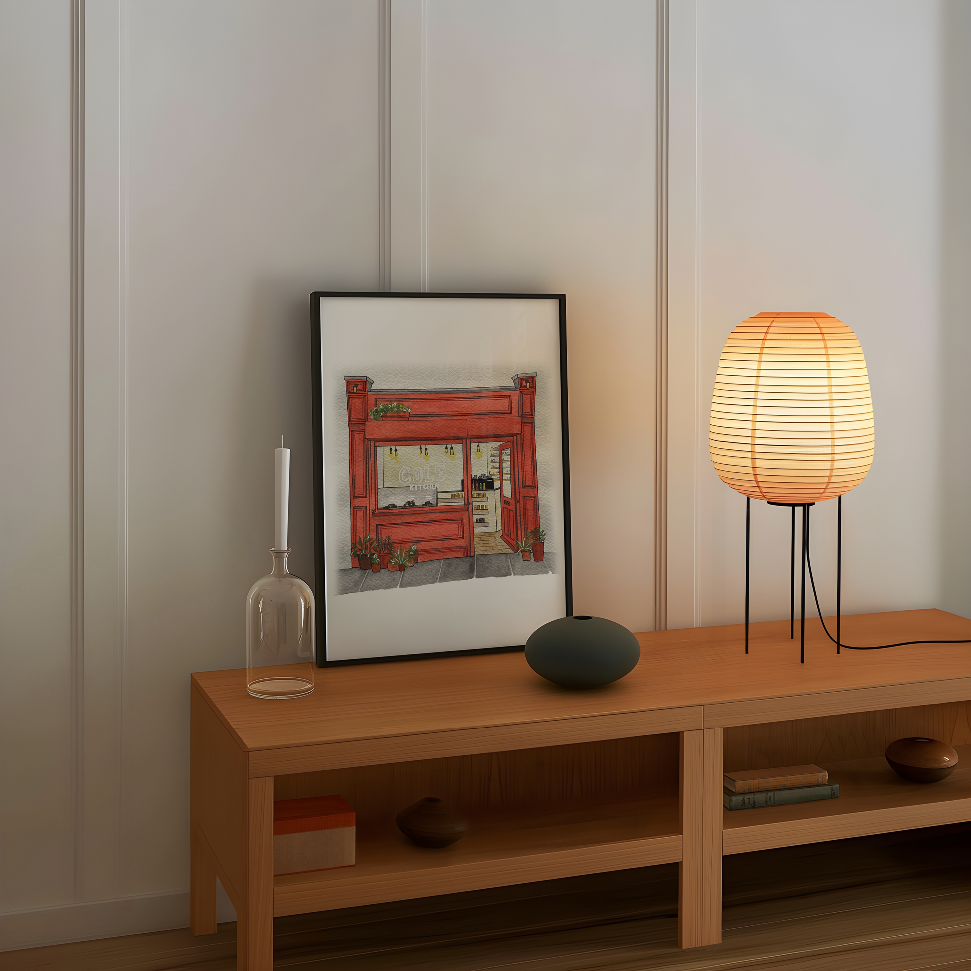 Wooden shelf with a framed picture, candle, vase, and lamp against a white wall.