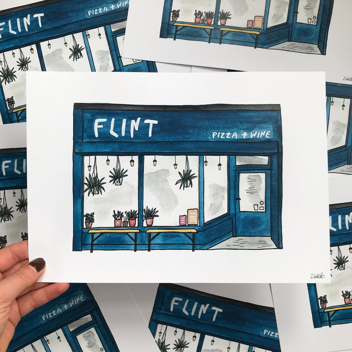 Illustration of a pizza and wine shop named 'Flint' held by a hand.