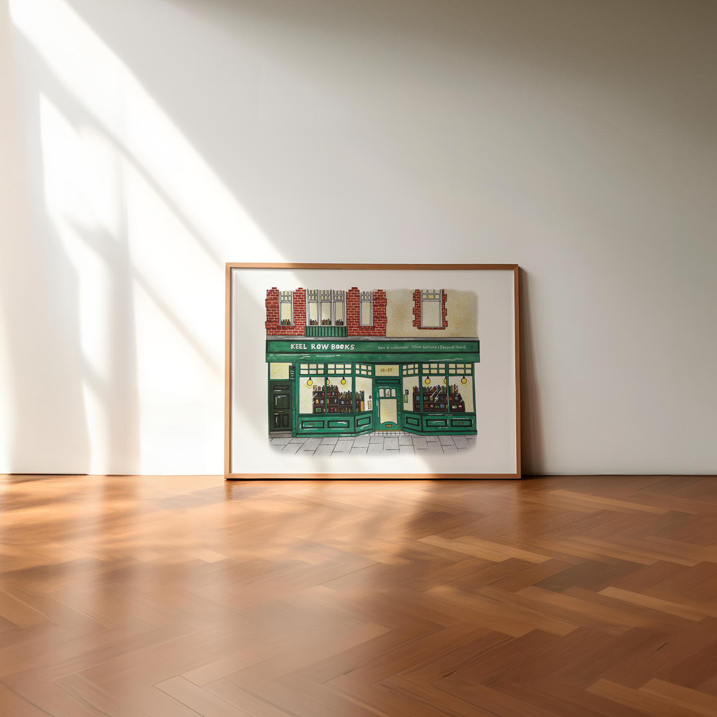 Framed artwork of Keel Row Books, Whitley Bay on a white wall with wooden floor
