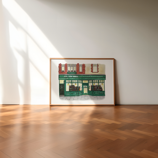 Framed artwork of Keel Row Books, Whitley Bay on a white wall with wooden floor