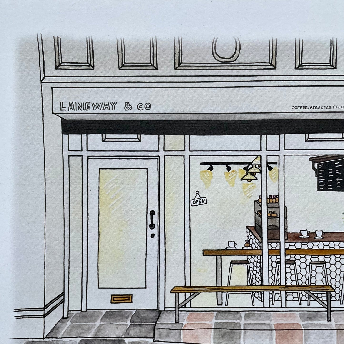 Illustration of a coffee shop named 'LANEWAY & CO' with a door and interior.