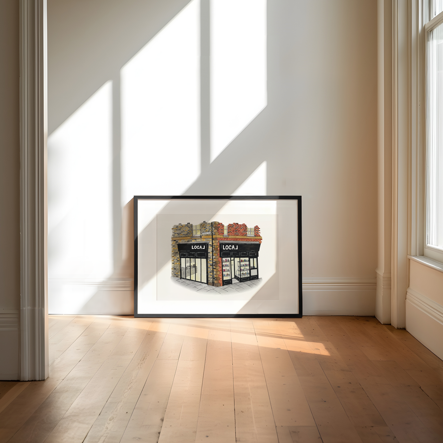 Framed artwork of Local Jesmond on a wall in a bright room with sunlight streaming through windows.