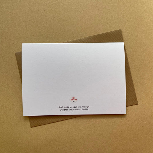 White card with red text on a brown envelope against a brown background