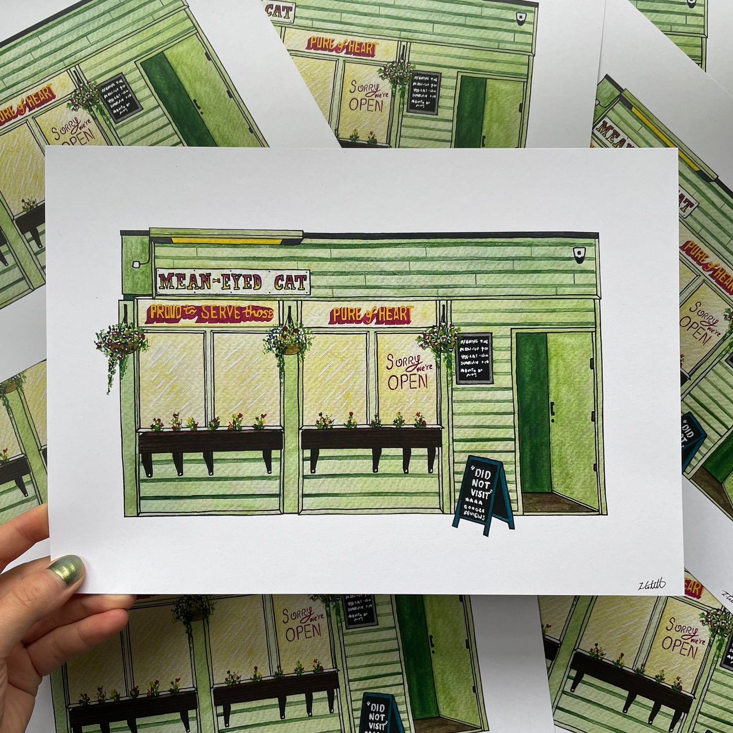 Illustration of the Mean Eyed Cat bar Newcastle held by a hand on a patterned background.