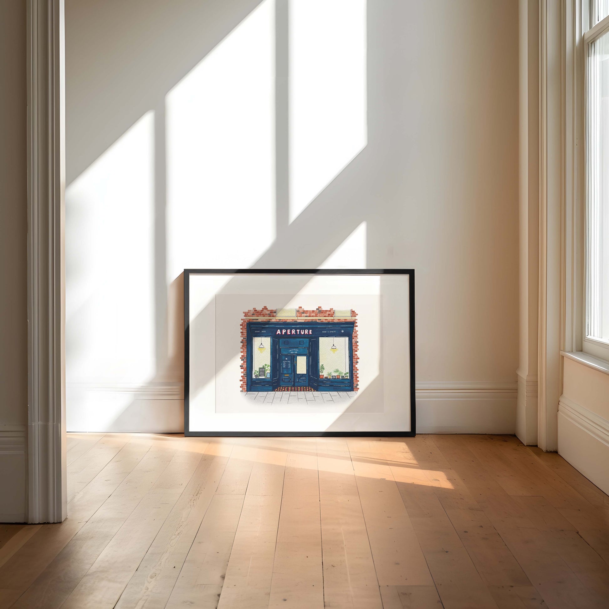 Framed artwork of aperture alehouse, north shields propped against a wall with sunlight casting shadows