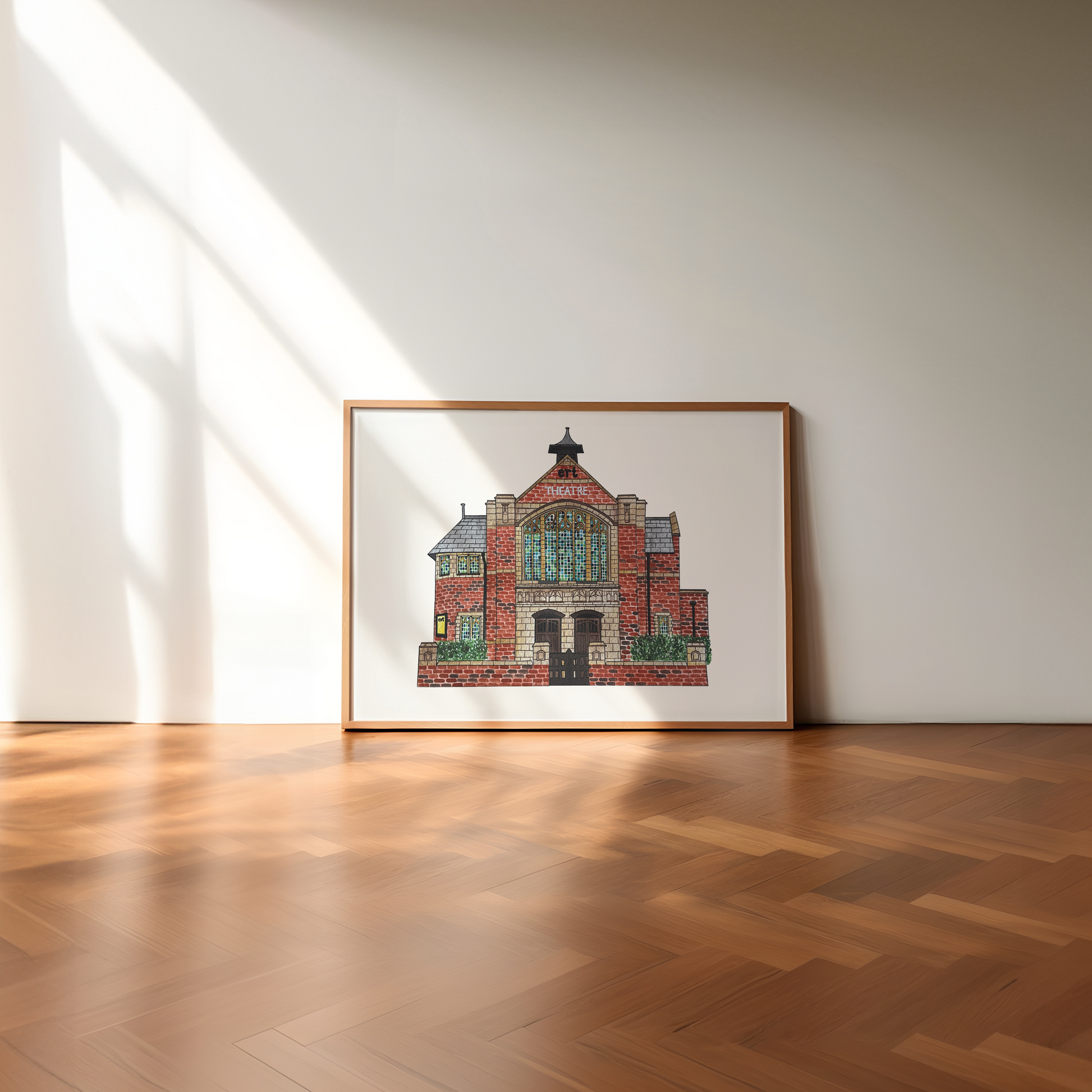 Framed artwork of a east riding theatre beverley on a white wall with wooden floor
