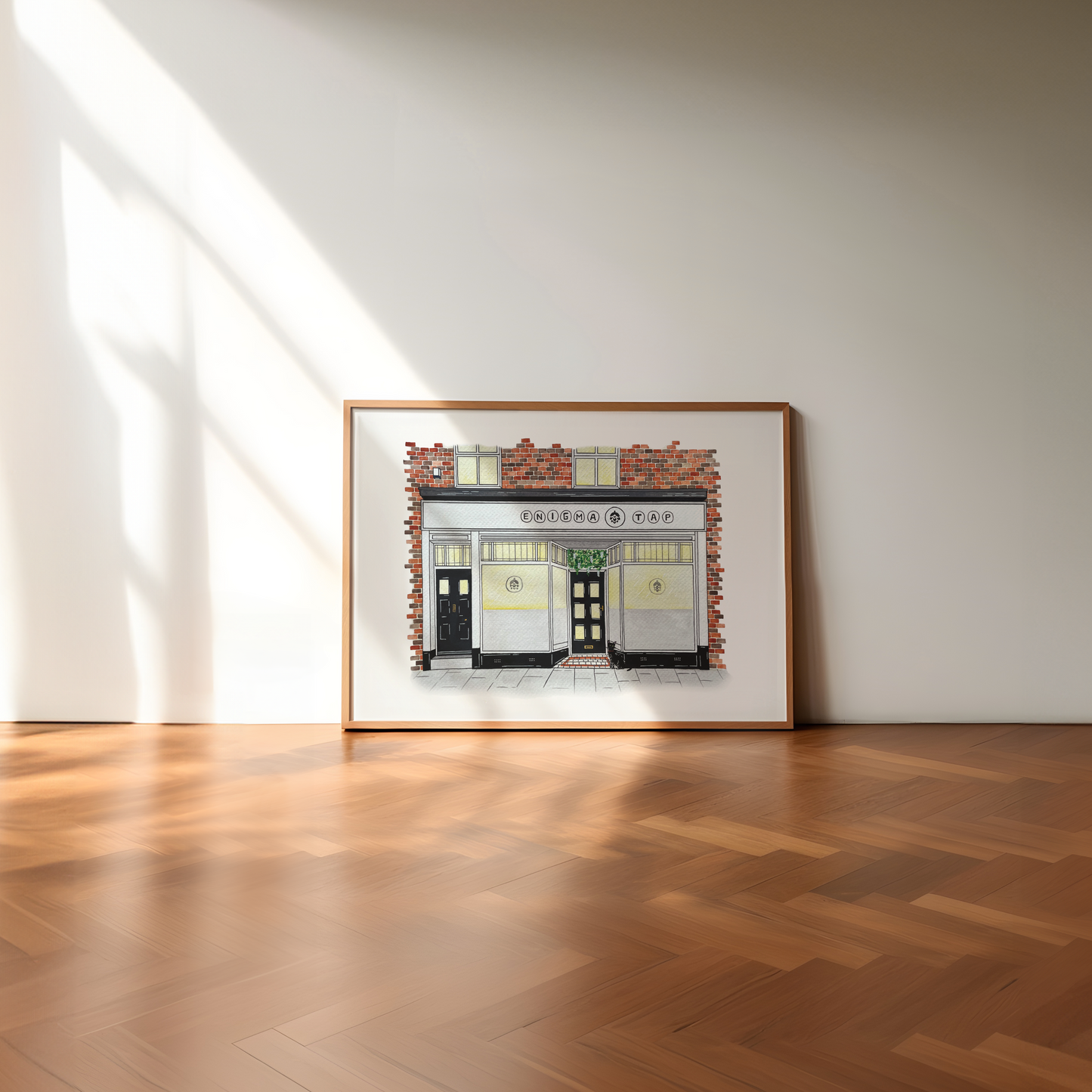 Framed artwork of enigma tap north shields on a white wall with wooden floor