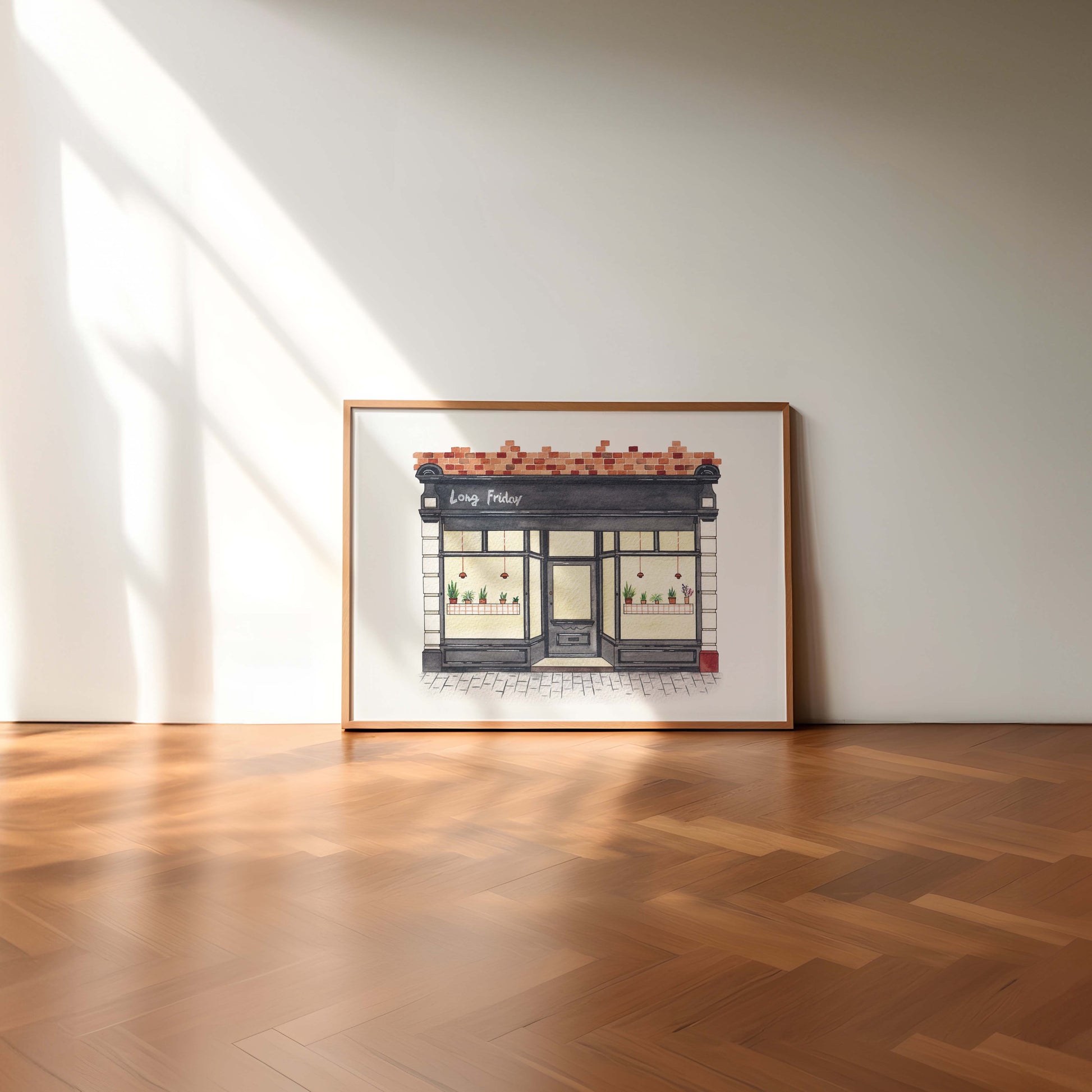 Framed artwork of Long Friday Jesmond on a wall in a room with wooden flooring