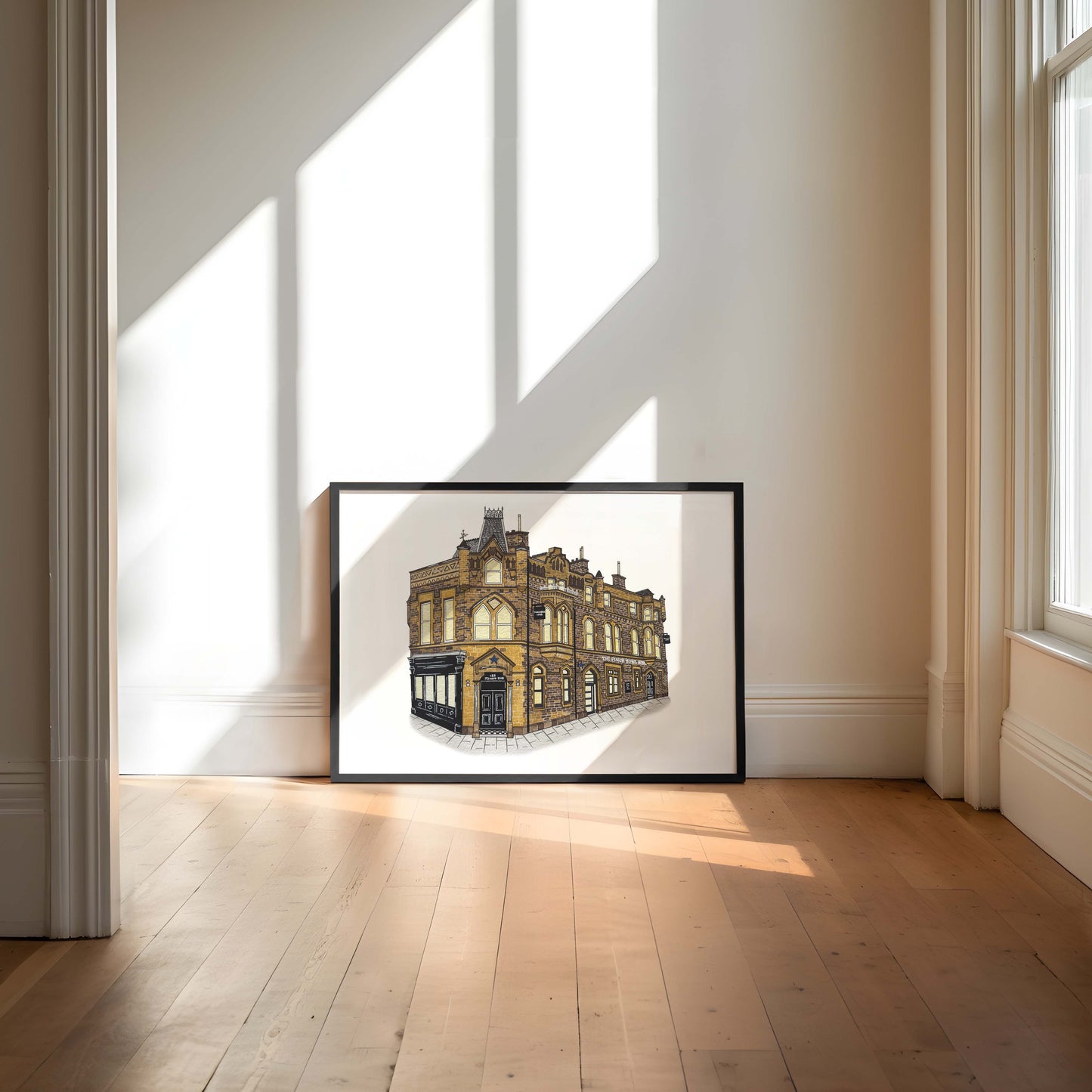 Framed artwork of the punch bowl hotel  on a white background in a room with large windows.